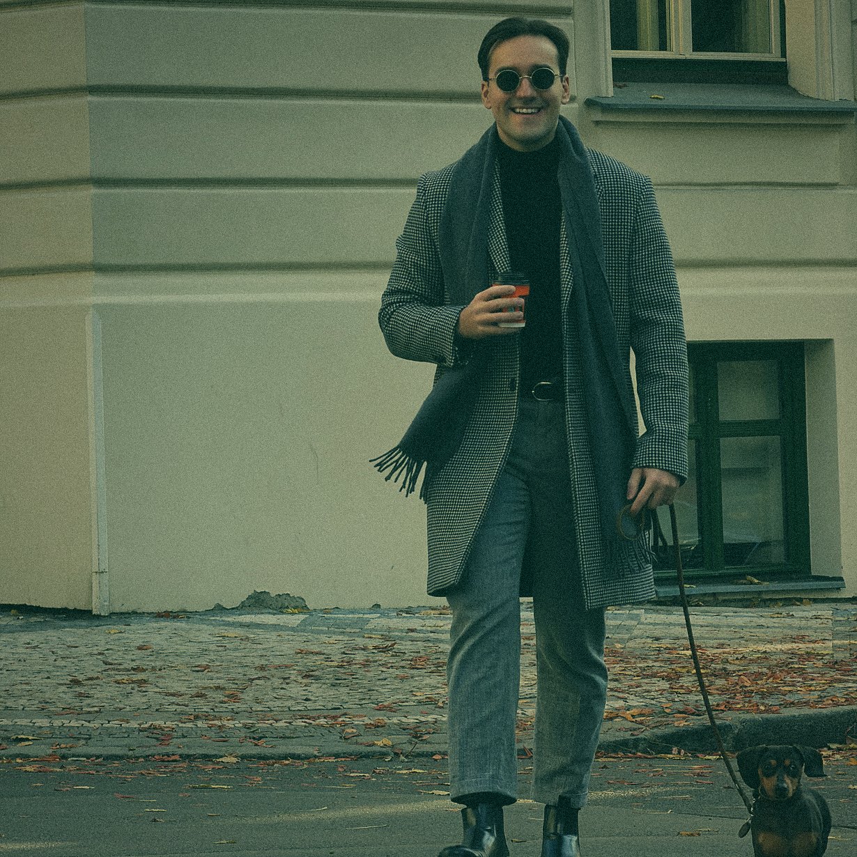 Simon Rico in a coat walking Luna the dachshund in Prague