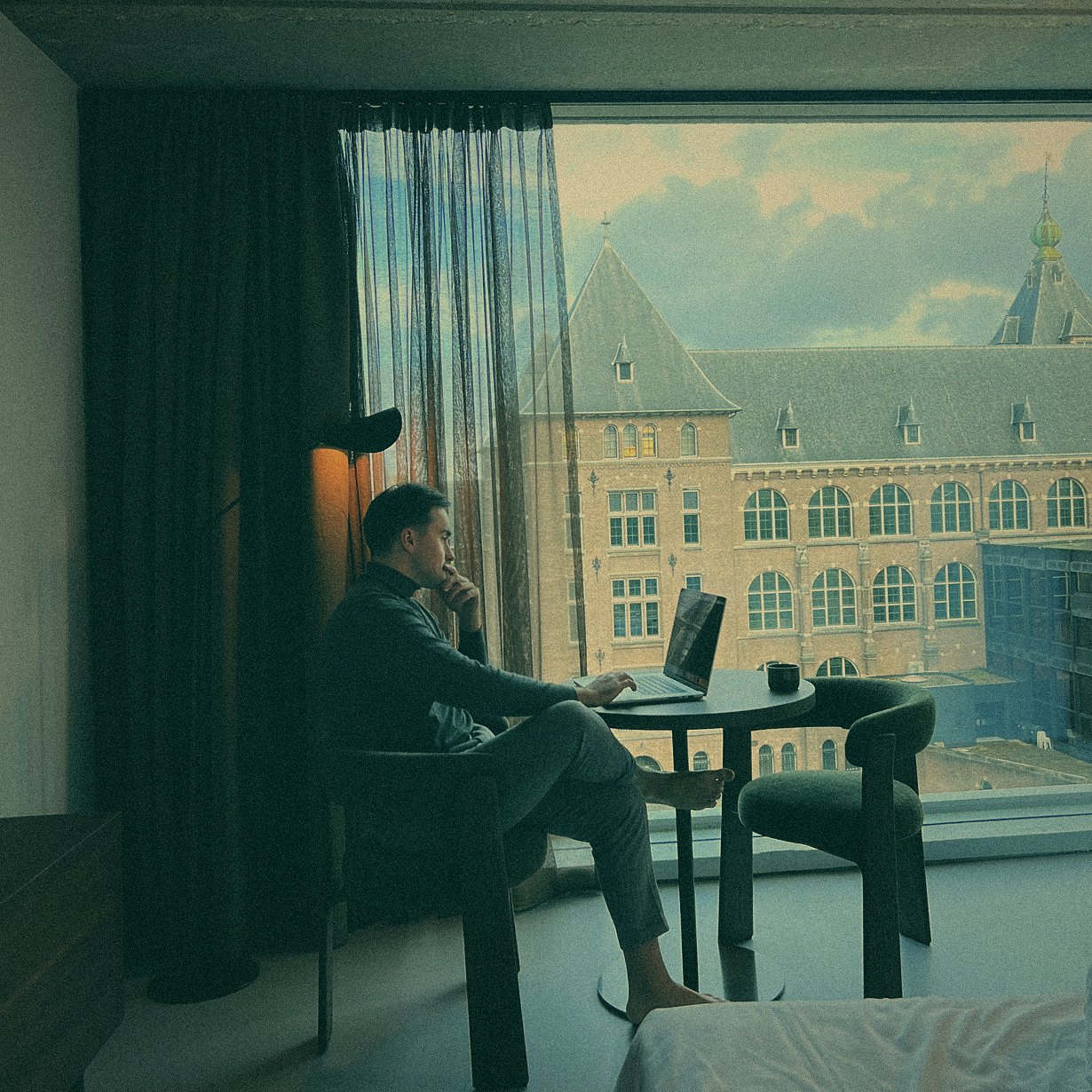 Simon Rico working on a laptop by a hotel window